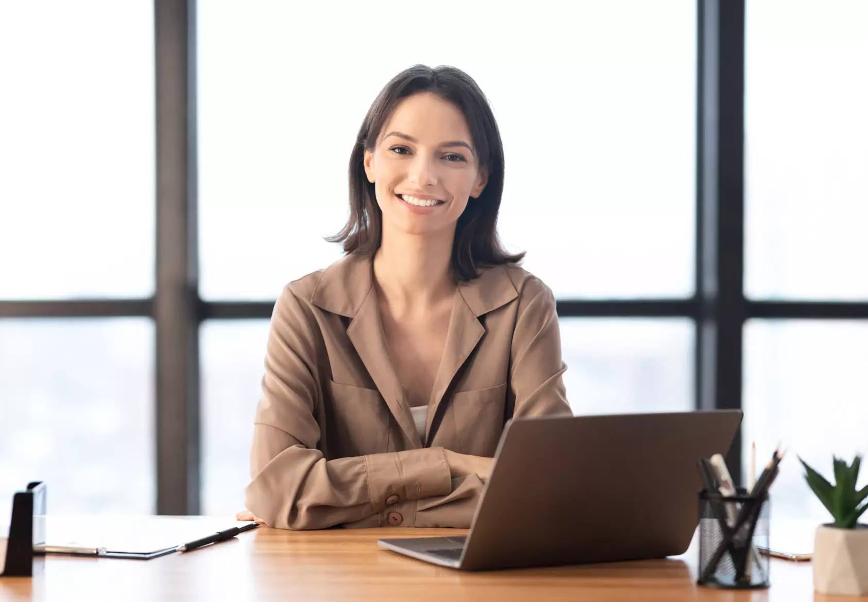 Travel agent smiling at a desk with a laptop
