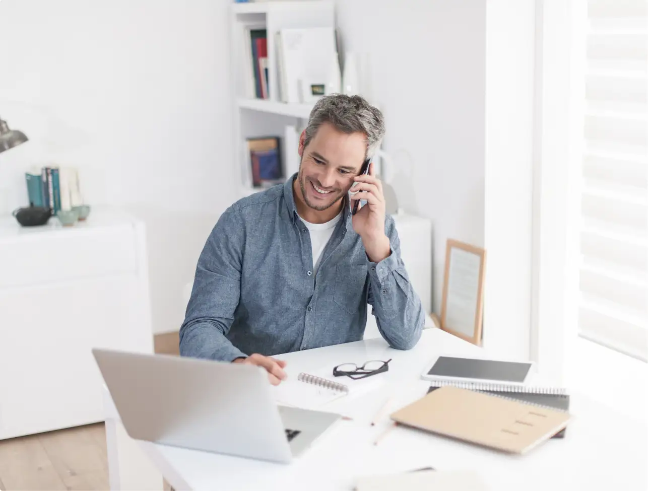 Travel agent smiling at a desk with a laptop